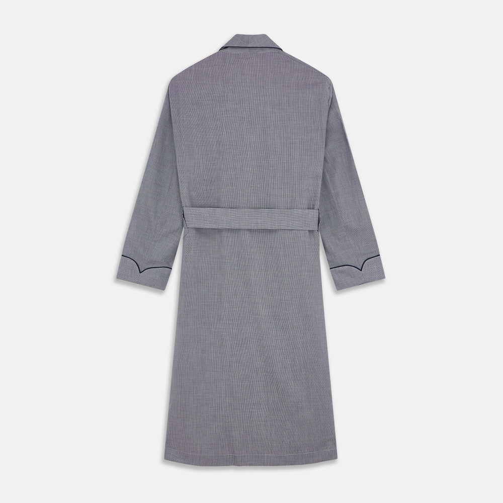The Navy Houndstooth Wool Arnold Gown by Turnbull & Asser features a shawl collar, front chest pocket, long sleeves, and a matching fabric belt tied at the waist.