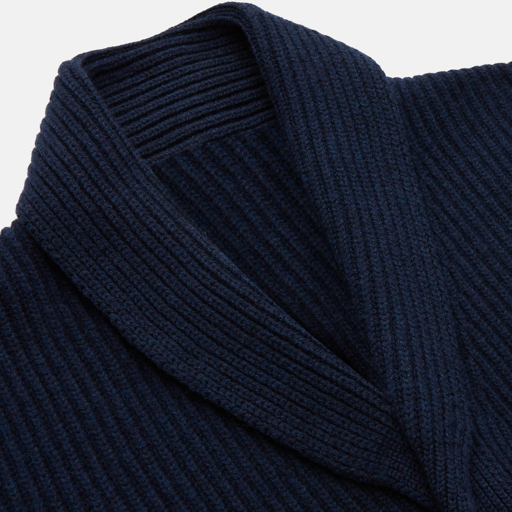 The Deep Navy Cashmere Baldwin Gown by Turnbull & Asser features a ribbed knit, long sleeves, shawl collar, two front pockets, and a waist tie—ideal as luxury loungewear or a chic navy dressing gown.