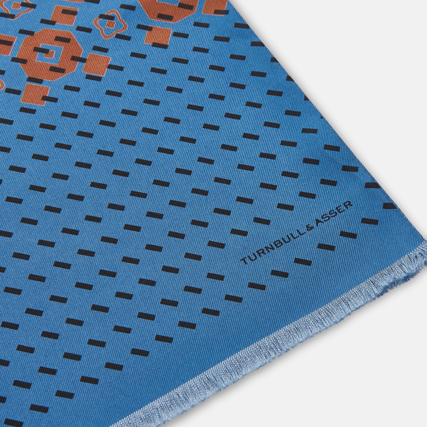 View 2 of product The Turnbull & Asser Turquoise Octagonal Pattern Silk Pin Fringe Scarf features a turquoise silk base with black diagonal lines, a central brown octagonal design, and short fringe at both ends—perfect as an eye-catching accent.