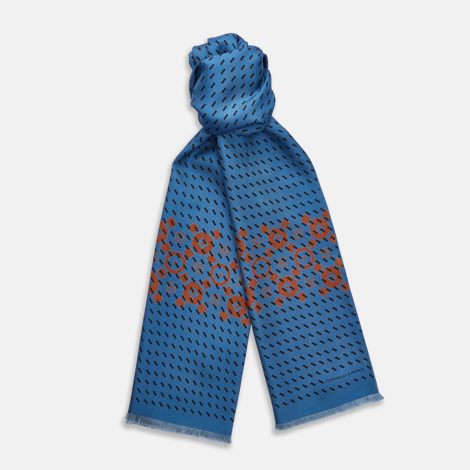 View 1 of product The Turnbull & Asser Turquoise Octagonal Pattern Silk Pin Fringe Scarf features a turquoise silk base with black diagonal lines, a central brown octagonal design, and short fringe at both ends—perfect as an eye-catching accent.