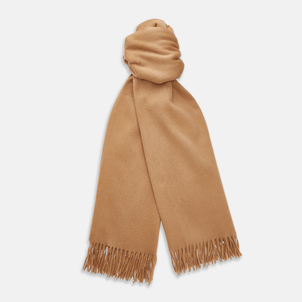 The Turnbull & Asser Camel Brown Cashmere Scarf features soft cashmere and fringed ends, neatly folded on a white background—an essential winter accessory.