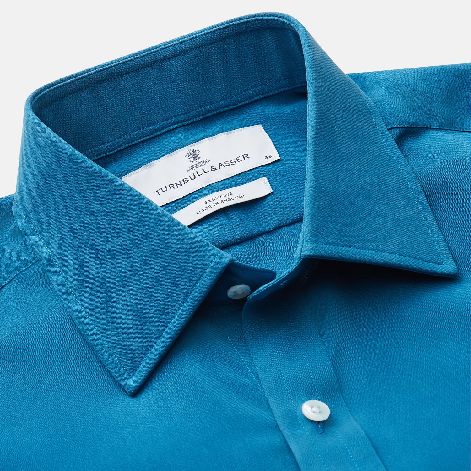 View 3 of product The Turnbull & Asser Blue Silk Regular Fit Mayfair Shirt features long sleeves, a pointed collar, and white buttons in a solid bright blue; displayed flat on a white background.