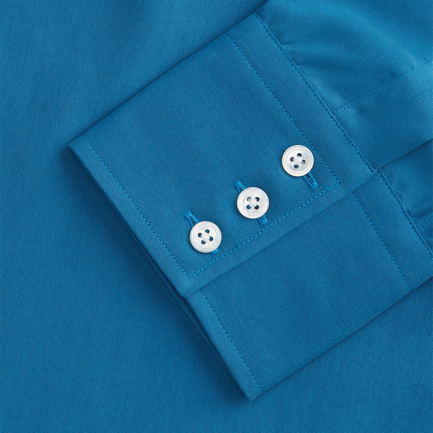 View 4 of product The Turnbull & Asser Blue Silk Regular Fit Mayfair Shirt features long sleeves, a pointed collar, and white buttons in a solid bright blue; displayed flat on a white background.