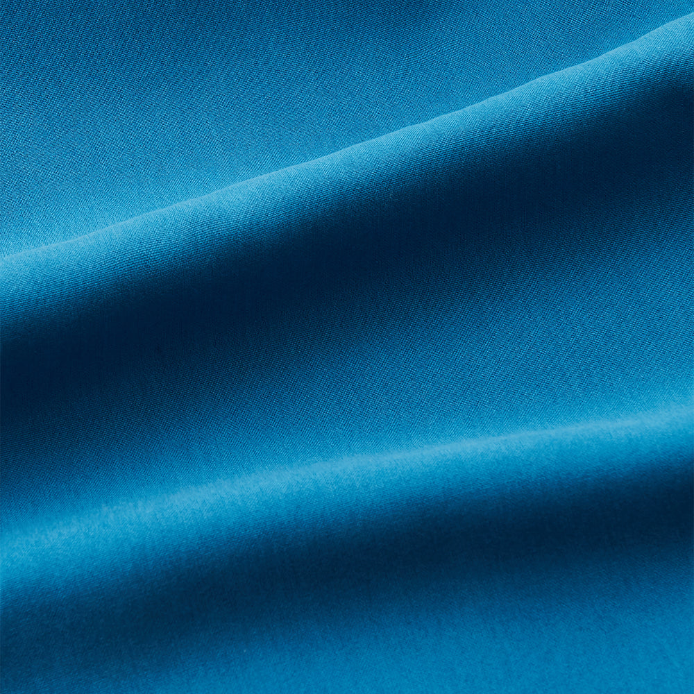 The Turnbull & Asser Blue Silk Regular Fit Mayfair Shirt features long sleeves, a pointed collar, and white buttons in a solid bright blue; displayed flat on a white background.