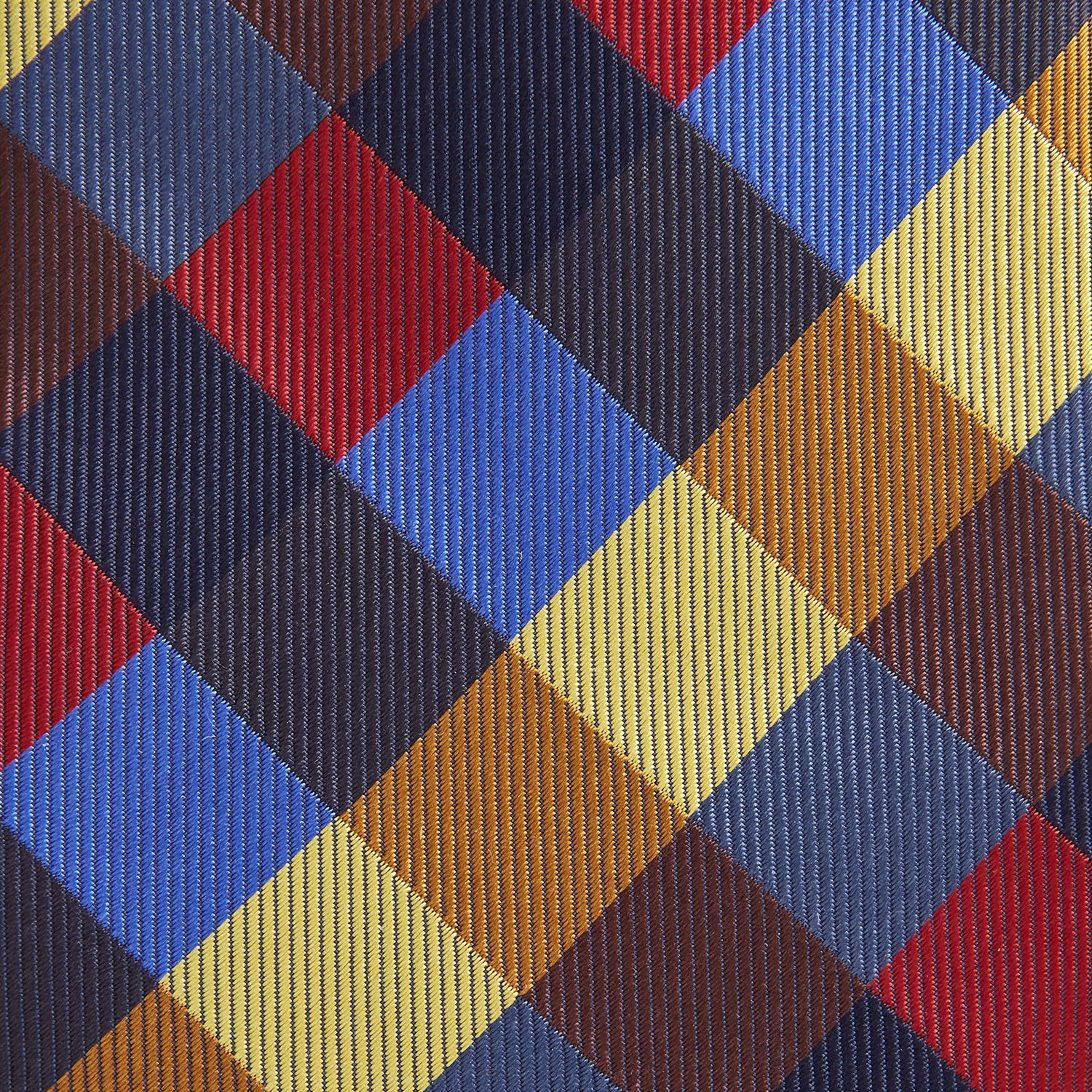 View 2 of product The Turnbull & Asser Blue, Red and Yellow Checker Silk Tie features a bold checkered pattern in red, blue, yellow, brown, and black tones, shown rolled up against a white background.