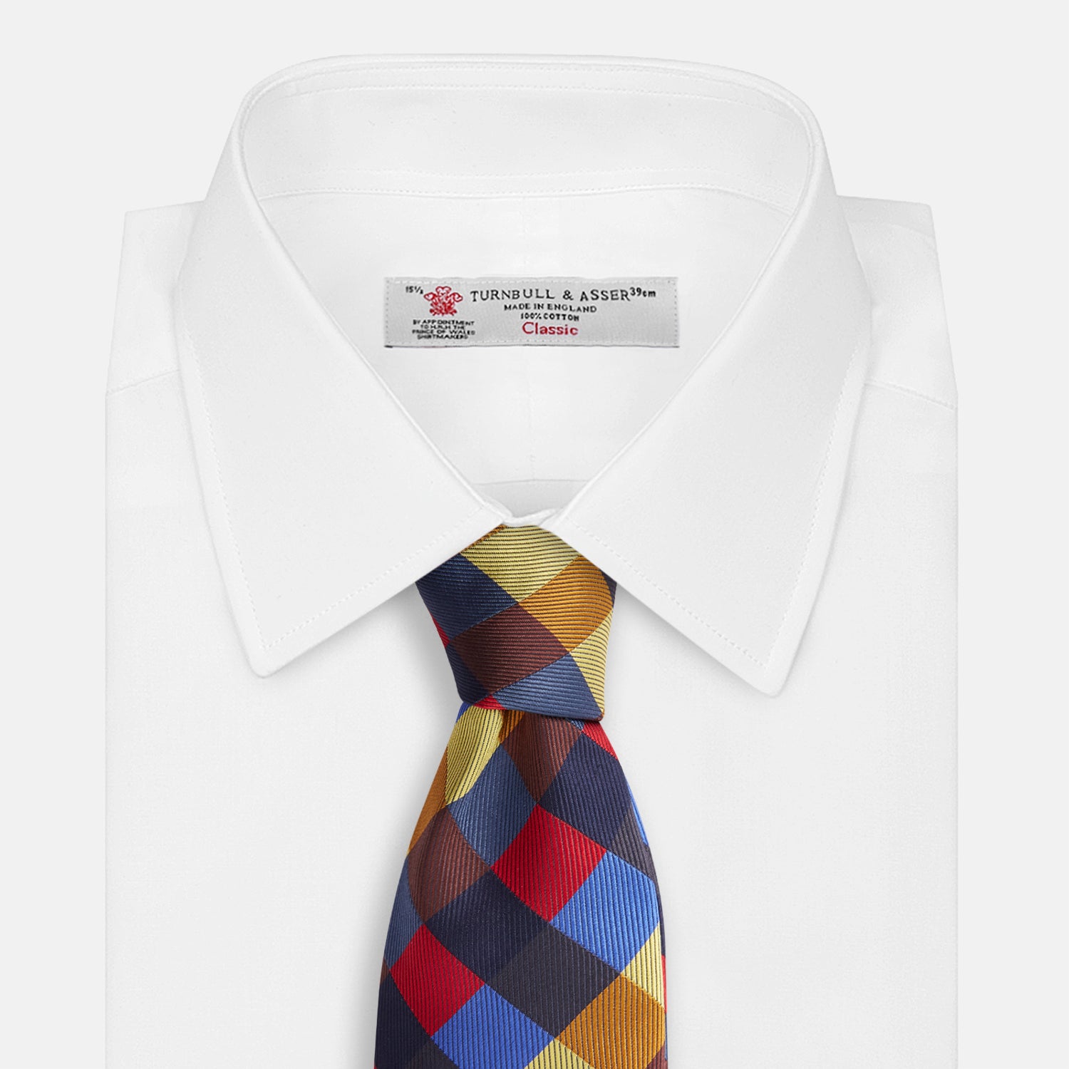 View 4 of product The Turnbull & Asser Blue, Red and Yellow Checker Silk Tie features a bold checkered pattern in red, blue, yellow, brown, and black tones, shown rolled up against a white background.