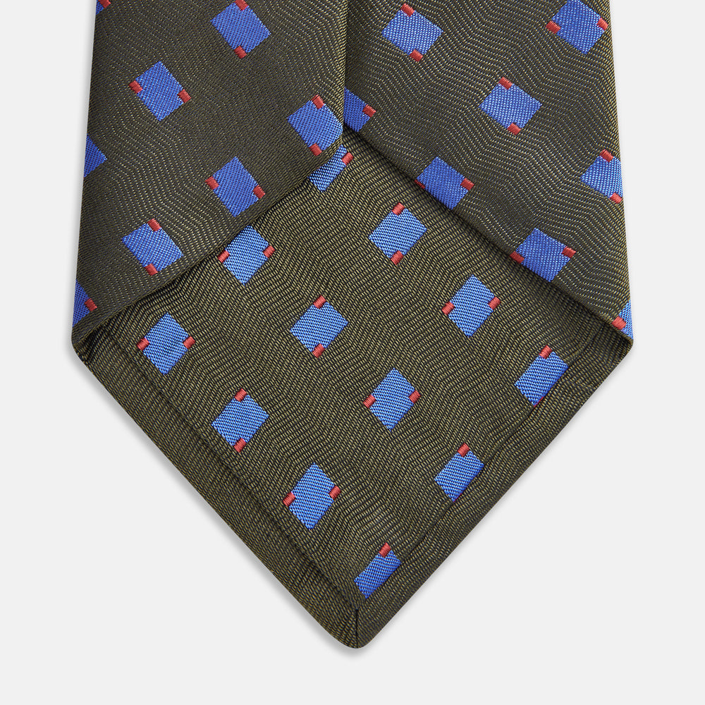 The Turnbull & Asser Dark Green and Blue Tile Silk Tie showcases a classic tile pattern with blue and red squares on herringbone fabric.
