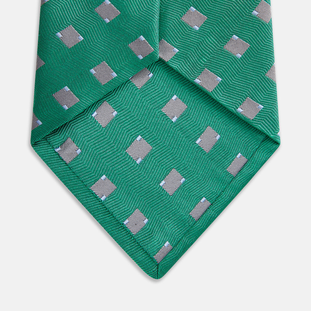 The Turnbull & Asser Kelly Green and Grey Tile Silk Tie features a subtle chevron texture and classic grey tile pattern, displayed rolled on a white background.