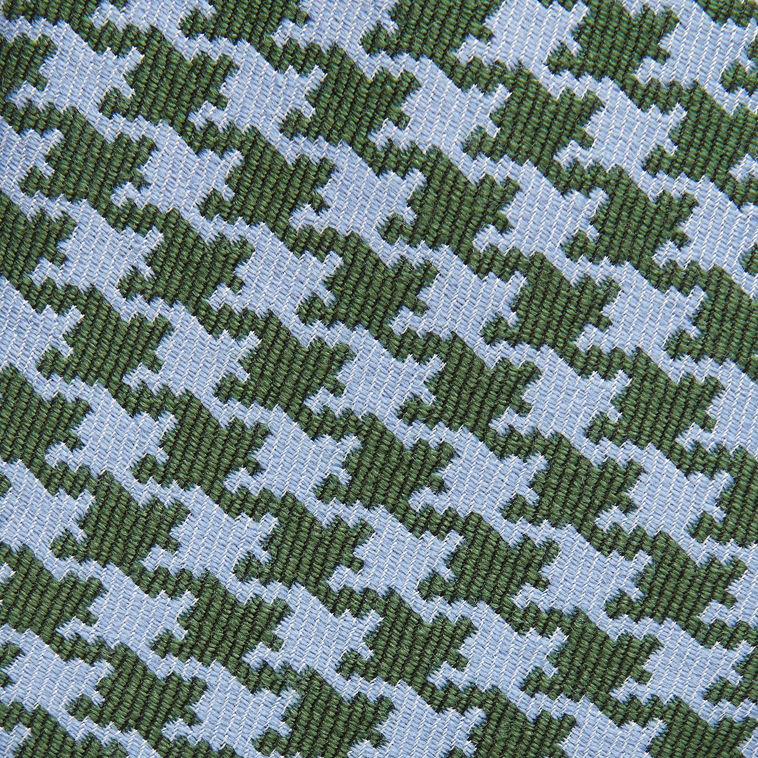View 2 of product The Turnbull & Asser Green and Blue Houndstooth Wool Blend Tie is rolled up, showcasing its classic pattern against a simple white background.