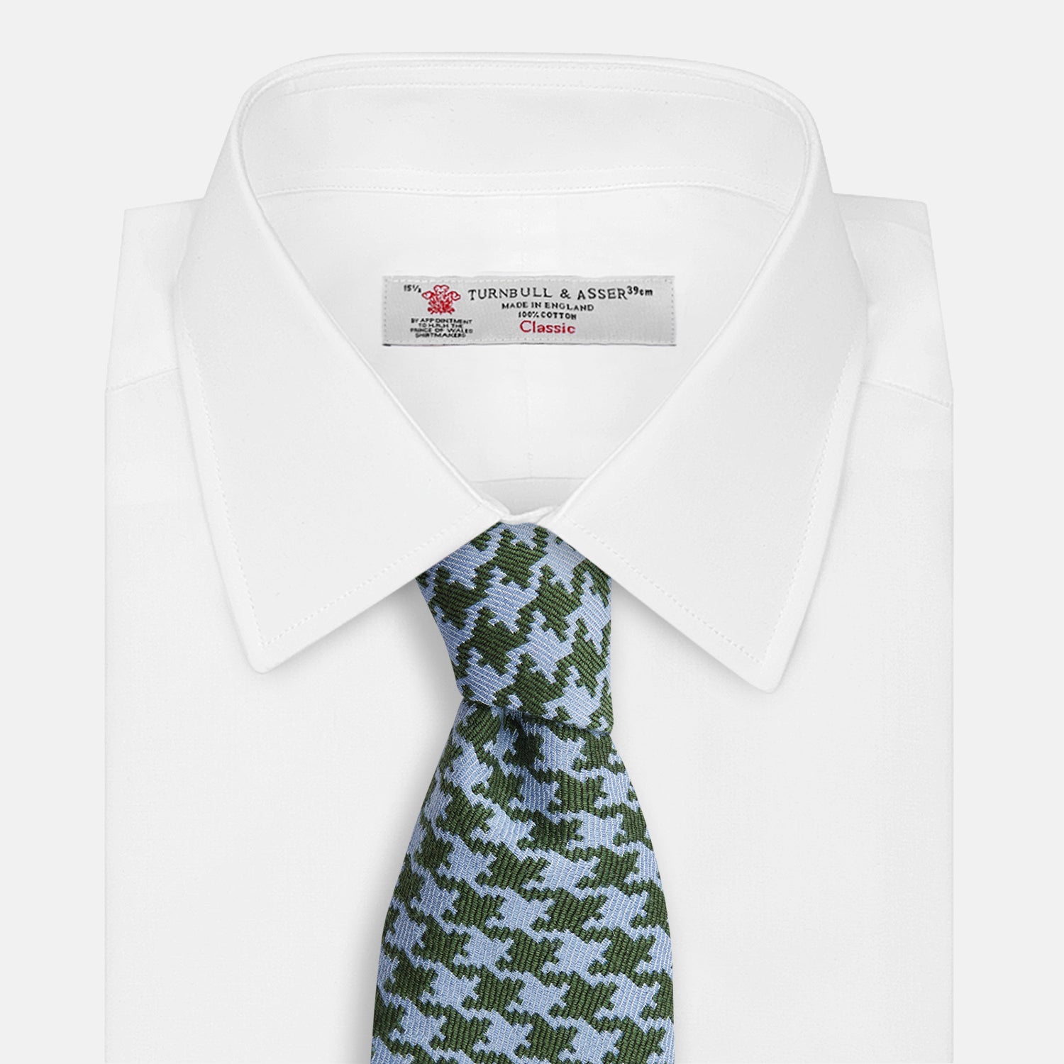 View 4 of product The Turnbull & Asser Green and Blue Houndstooth Wool Blend Tie is rolled up, showcasing its classic pattern against a simple white background.