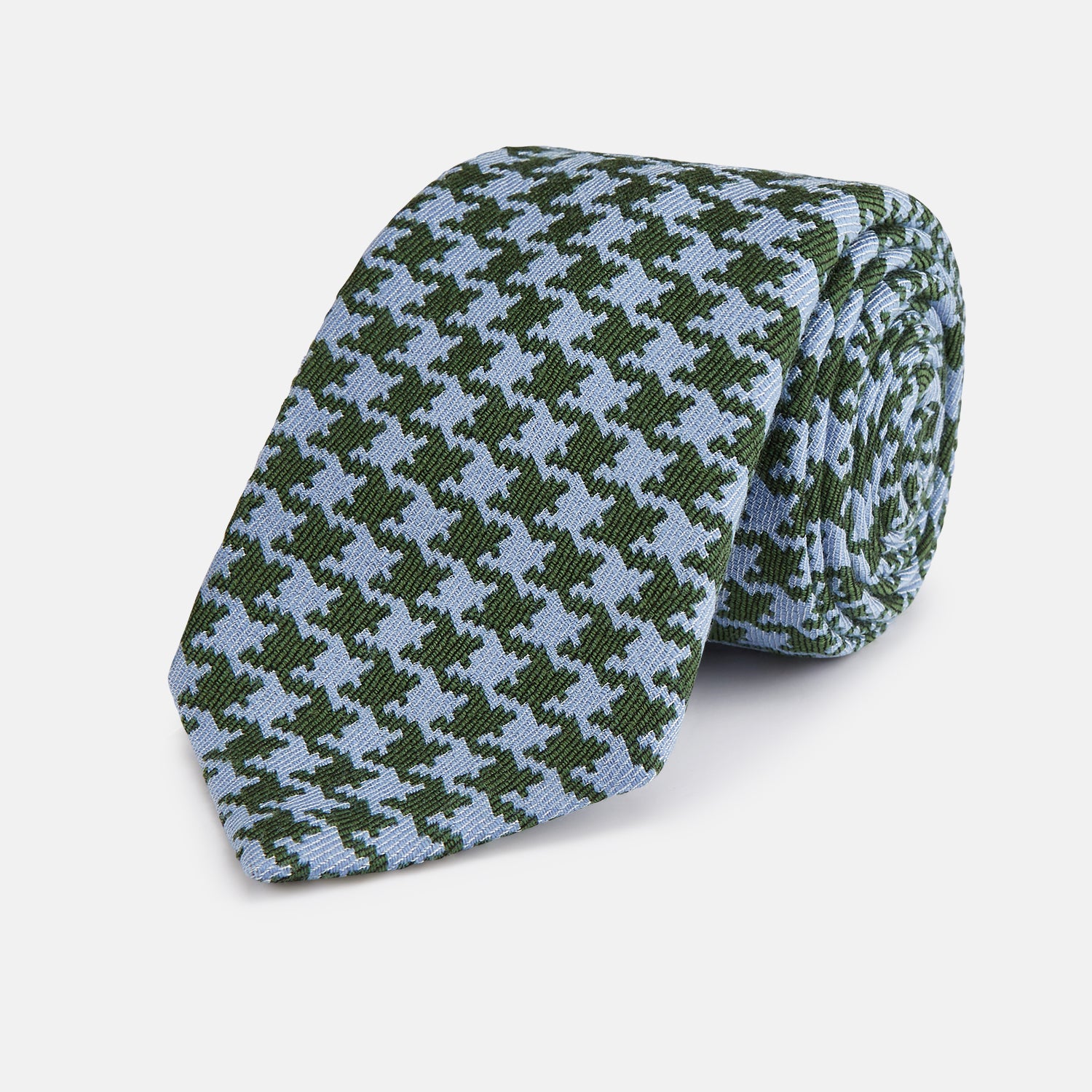 View 1 of product The Turnbull & Asser Green and Blue Houndstooth Wool Blend Tie is rolled up, showcasing its classic pattern against a simple white background.
