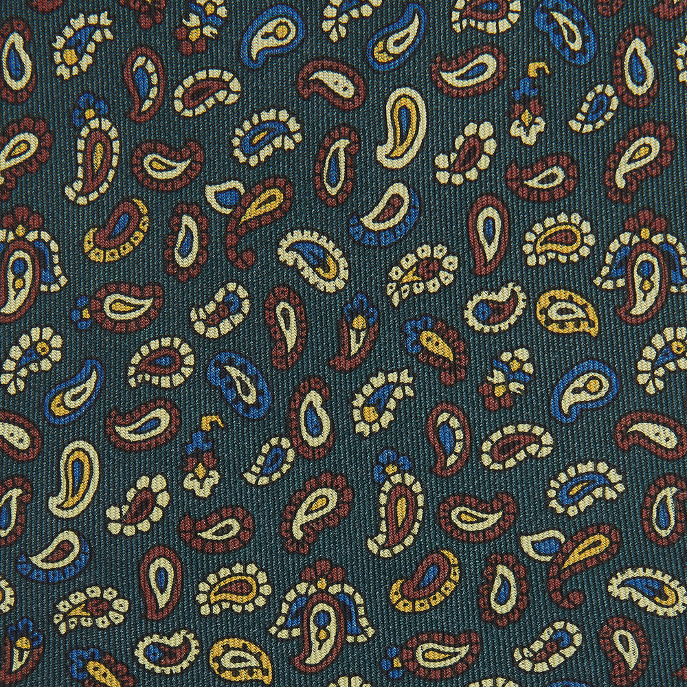 The Marine Blue Paisley Silk Tie by Turnbull & Asser features a vibrant paisley pattern on a rich marine blue silk background—an elegant accessory for any occasion.