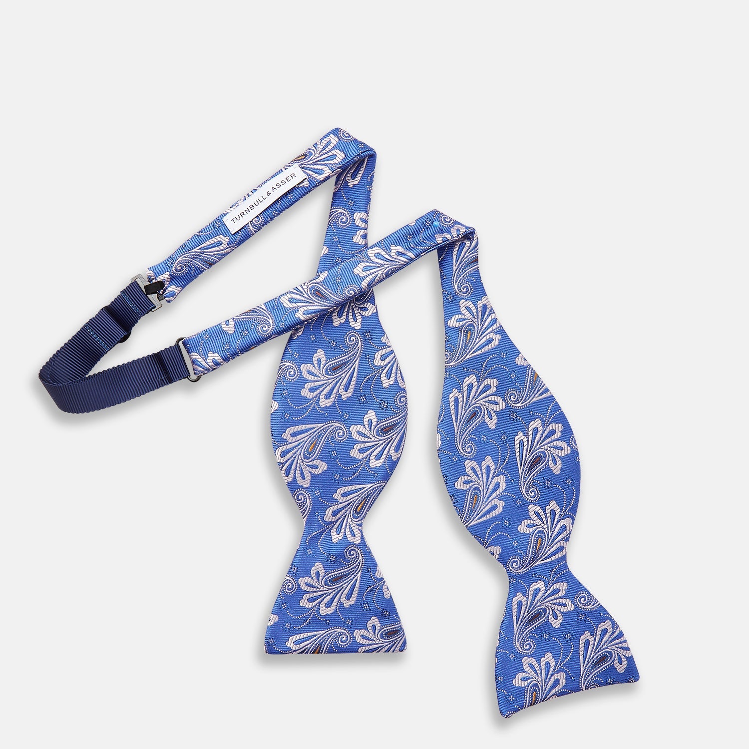 View 3 of product The Turnbull & Asser French Blue Paisley Silk Bow Tie features a white and silver floral paisley pattern, is self-tying, and is shown against a plain white background.