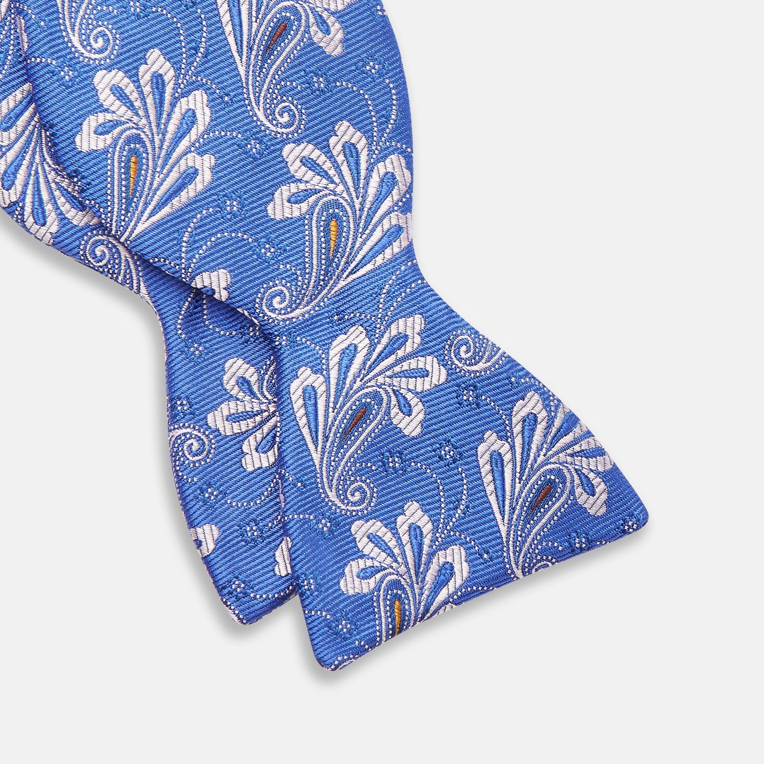 View 2 of product The Turnbull & Asser French Blue Paisley Silk Bow Tie features a white and silver floral paisley pattern, is self-tying, and is shown against a plain white background.