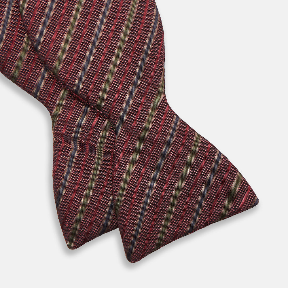 The Turnbull & Asser Claret and Green Multi Stripe Silk and Linen Bow Tie features diagonal stripes in red, beige, and green, shown on a plain white background.