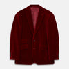 View 1 of product The Turnbull & Asser Wine Velvet Barrington Blazer, tailored in Italy, features a deep red hue, notched lapel, two front buttons, three pockets, and cuff button details. Shown against a plain white background.
