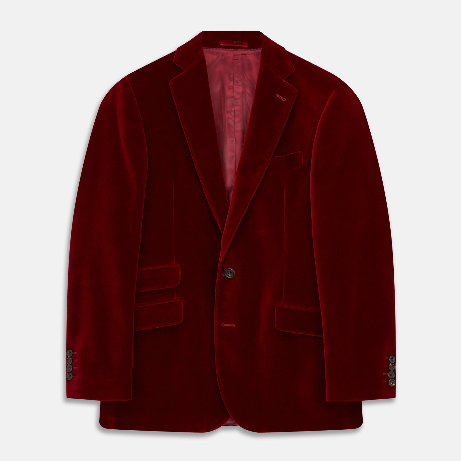 View 1 of product The Turnbull & Asser Wine Velvet Barrington Blazer, tailored in Italy, features a deep red hue, notched lapel, two front buttons, three pockets, and cuff button details. Shown against a plain white background.