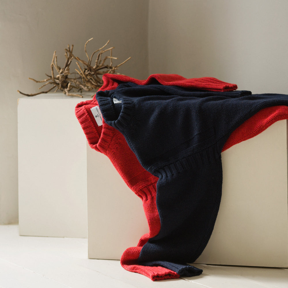 A man stands in the Turnbull & Asser Navy Lewis Guernsey Knitted Jumper.