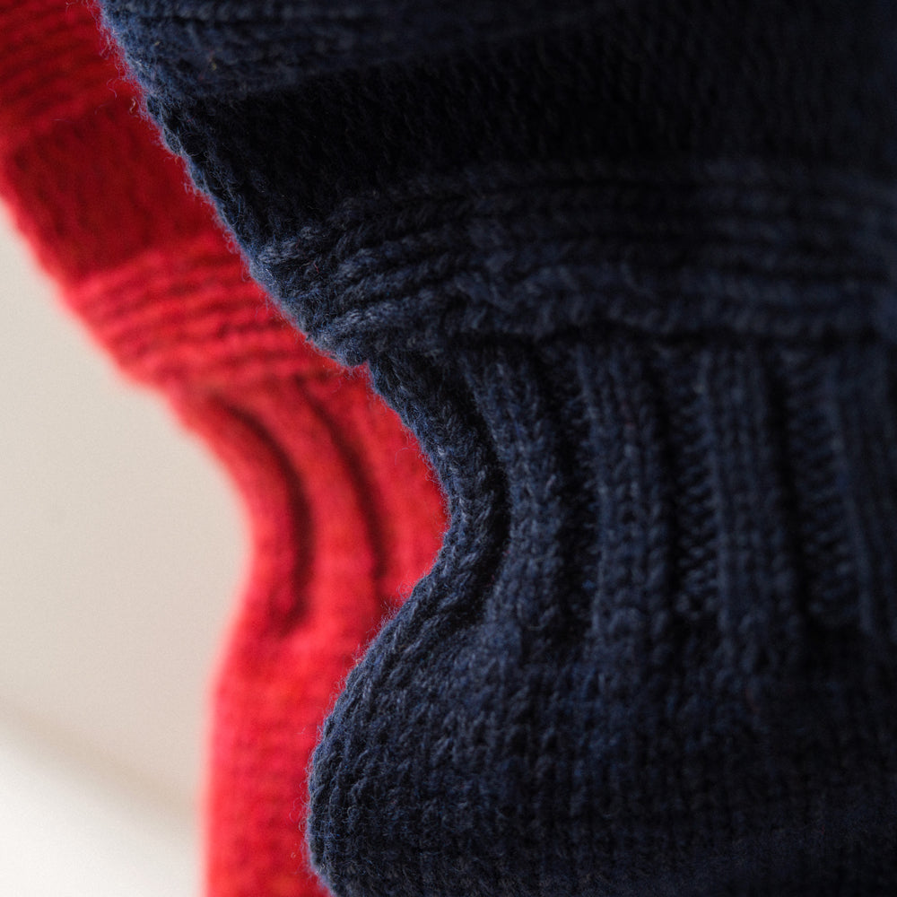 A man stands in the Turnbull & Asser Navy Lewis Guernsey Knitted Jumper.