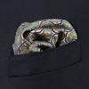 View 2 of product The Turquoise Flower Bloomsbury-Inspired Pattern Silk Pocket Square by Turnbull & Asser features a vibrant geometric floral motif with a turquoise border for a colorful, symmetrical accent.