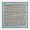 View 1 of product The Turquoise Flower Bloomsbury-Inspired Pattern Silk Pocket Square by Turnbull & Asser features a vibrant geometric floral motif with a turquoise border for a colorful, symmetrical accent.