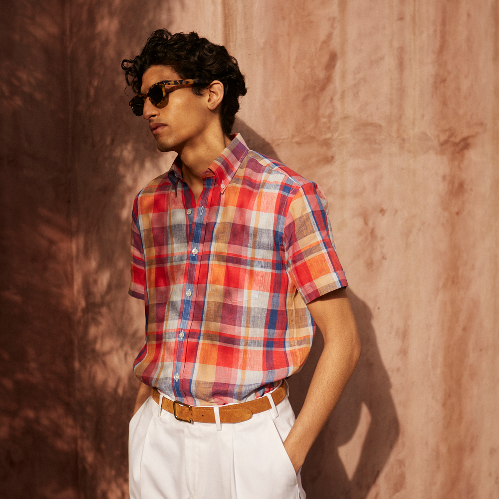 The Turnbull & Asser Red Madras Check Weekend Fit Short Sleeve Linen Shirt features a Dorset collar, white buttons, and a red, blue, white, and beige plaid pattern. Shown on a plain white background.