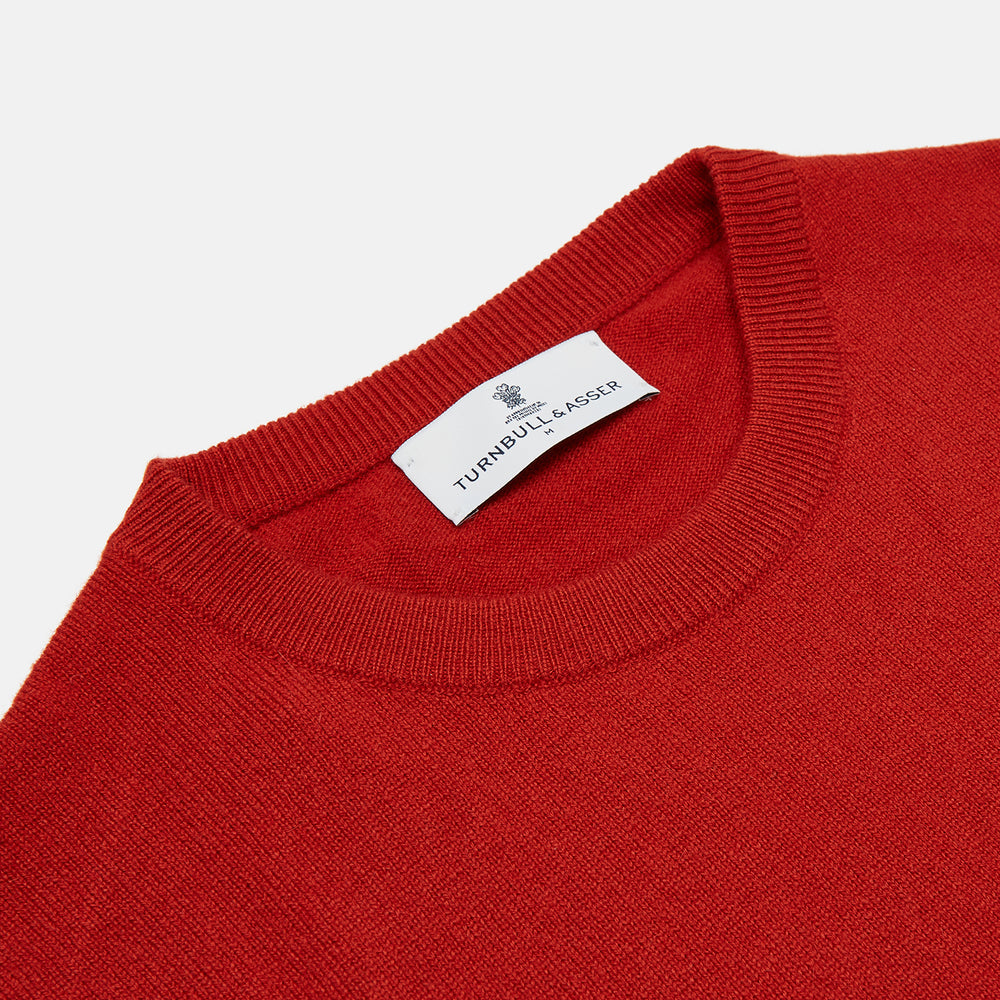 The Turnbull & Asser Red Cashmere Crewneck Jumper features long sleeves, ribbed cuffs and hem, showcasing classic Scottish knitwear elegance. Displayed on a white background.