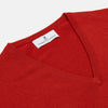 View 2 of product The Turnbull & Asser Red Cashmere V-Neck Jumper features long sleeves and ribbed cuffs and hem, shown laid flat on a white background.