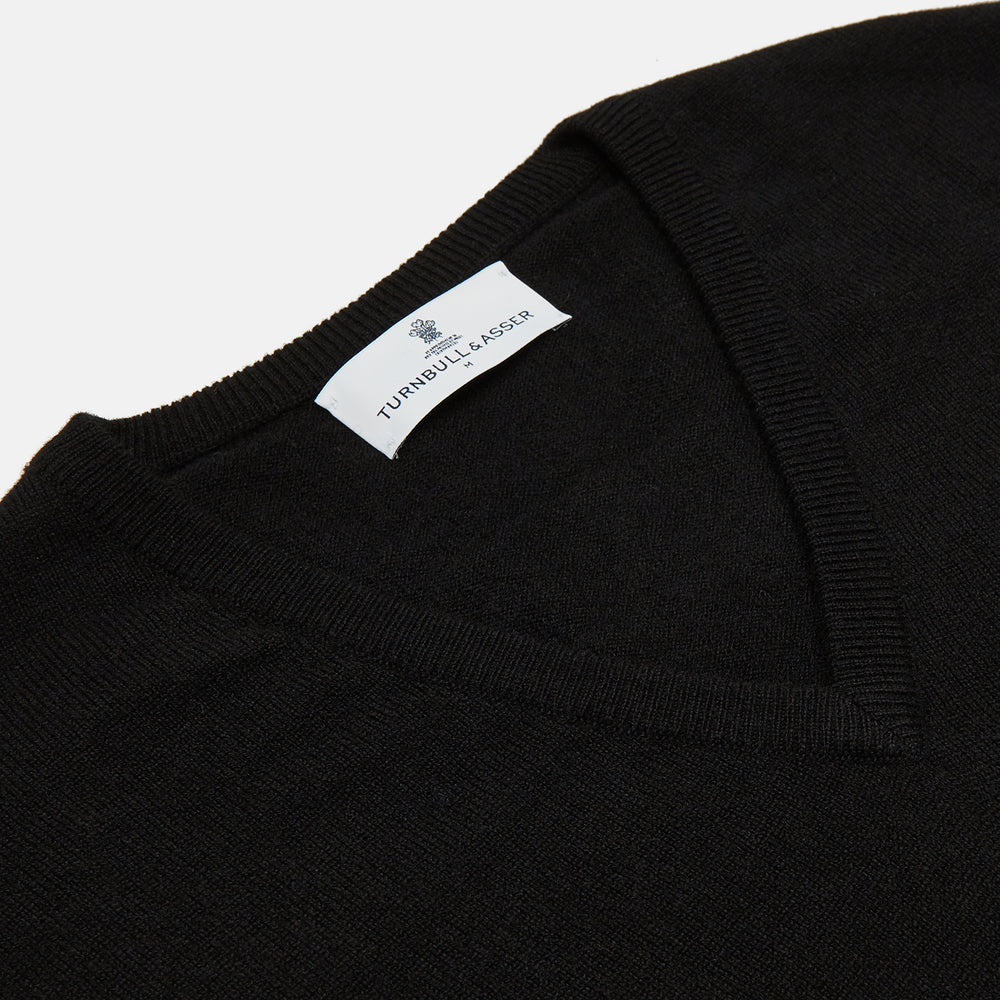 The Turnbull & Asser Black Cashmere Slipover, a sleeveless V-neck sweater vest made from pure cashmere, is shown flat against a white background.