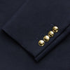 View 3 of product The Turnbull & Asser Navy Plain Wool Single Breasted Blazer features brass buttons on the front and cuffs, notched lapels, and multiple front pockets, shown laid flat against a white background.