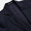 View 2 of product The Turnbull & Asser Navy Plain Wool Single Breasted Blazer features brass buttons on the front and cuffs, notched lapels, and multiple front pockets, shown laid flat against a white background.