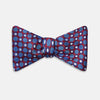 View 1 of product The Turnbull & Asser Burgundy and Blue Circle and Spot Silk Bow Tie showcases a formal patterned design of circles and spots on silk, presented on a plain white backdrop.