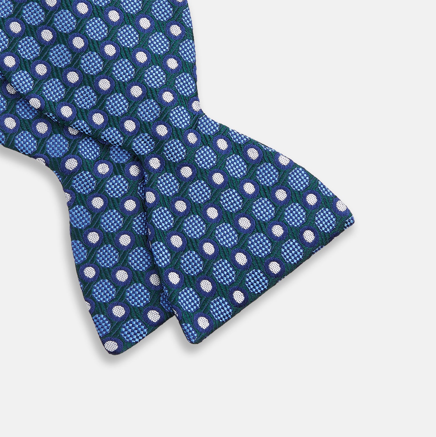 View 3 of product The Turnbull & Asser Forest Green and Blue Circle and Spot Silk Bow Tie showcases a blue, green, and white dotted pattern, set against a plain white background.