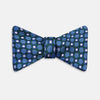 View 1 of product The Turnbull & Asser Forest Green and Blue Circle and Spot Silk Bow Tie showcases a blue, green, and white dotted pattern, set against a plain white background.