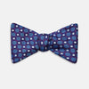 View 1 of product The Turnbull & Asser Plum and Blue Circle and Spot Silk Bow Tie, featuring blue with white and light blue dots on a purple background, is displayed on a plain white surface.