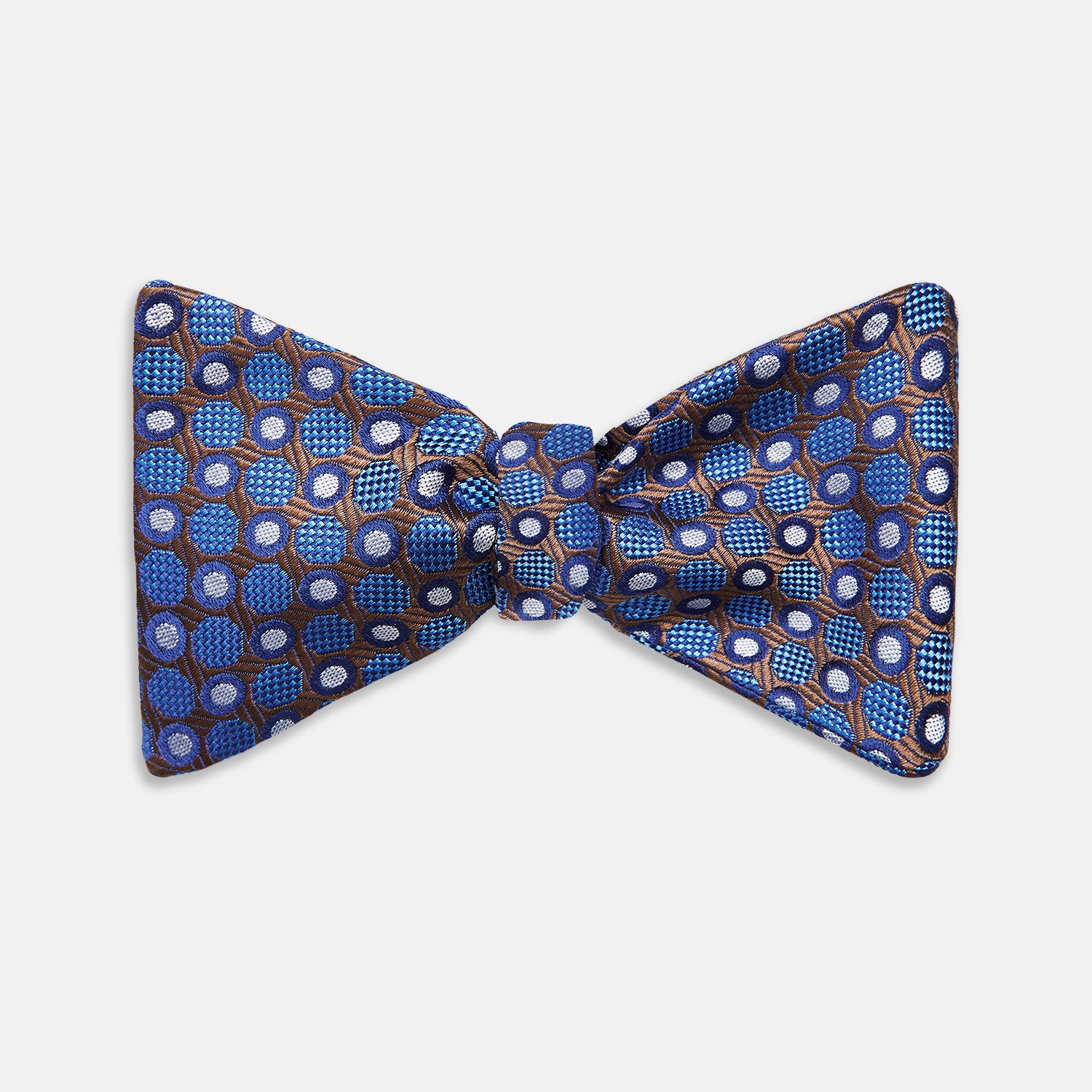 View 1 of product The Turnbull & Asser Brown and Blue Circle and Spot Silk Bow Tie features a blue silk base with light blue and brown circular dots on textured fabric, shown against a white background.
