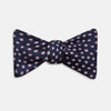 View 1 of product The Navy and Pink Paint Spot Silk Bow Tie by Turnbull & Asser features small, light pink oval dots evenly spaced on navy blue silk, creating a stylish formal accessory.