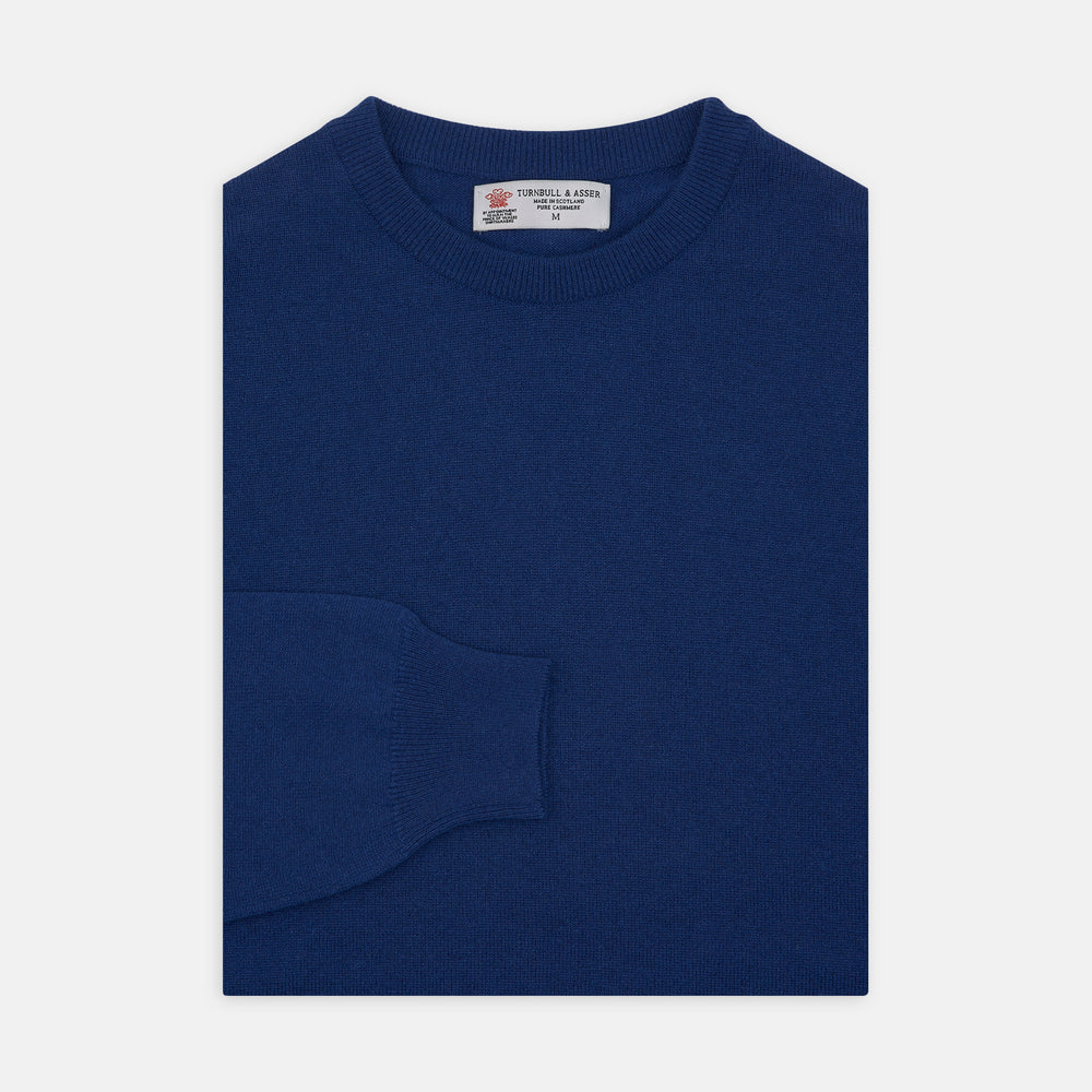 The Turnbull & Asser Blue Crew Neck Cashmere Jumper, neatly folded with ribbed collar and cuffs, is shown on a plain white background. A small label appears inside the collar.