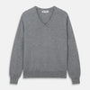 View 1 of product The Turnbull & Asser Flannel Grey V-Neck Cashmere Jumper, shown laid flat on a white background, features long sleeves and ribbed cuffs, hem, and neckline for a classic look with no visible patterns or embellishments.