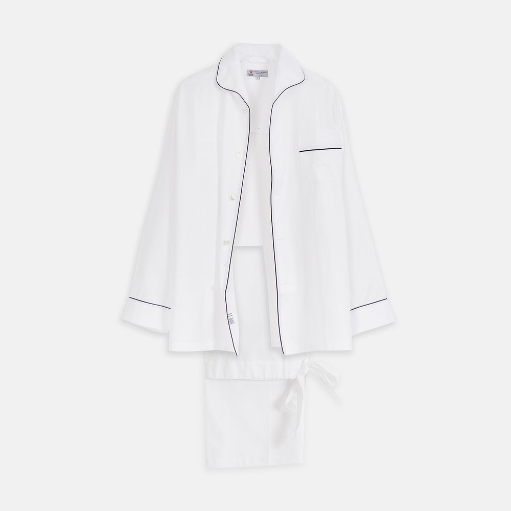 The Turnbull & Asser White Herringbone Piped Superfine Cotton Pyjama Set features a long-sleeve button-up top and drawstring pants with black piping, all crafted from superfine cotton and shown against a plain white background.