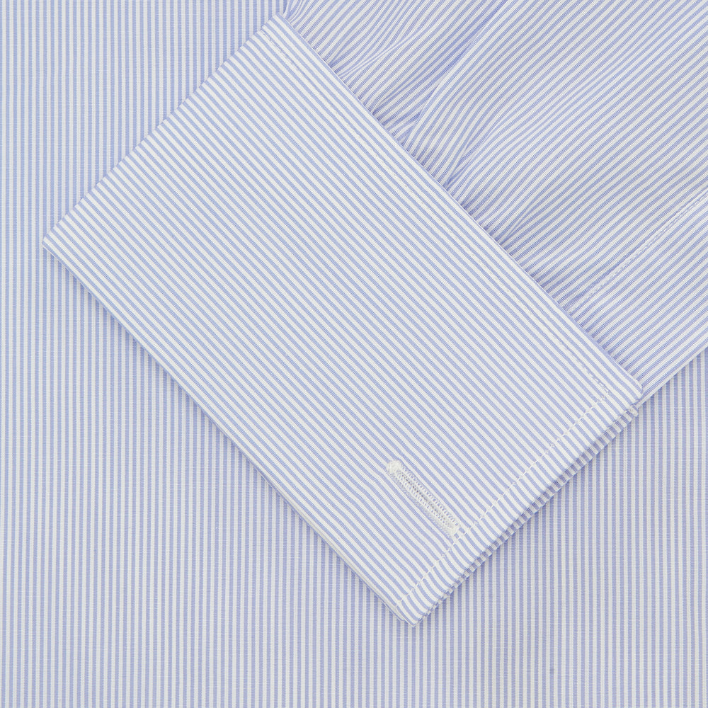 The Turnbull & Asser Blue and White Sea Island Quality Cotton Fine Bengal Stripe Shirt features a Regent collar, double cuffs, white buttons, and a front pocket. Displayed neatly folded against a plain white background.