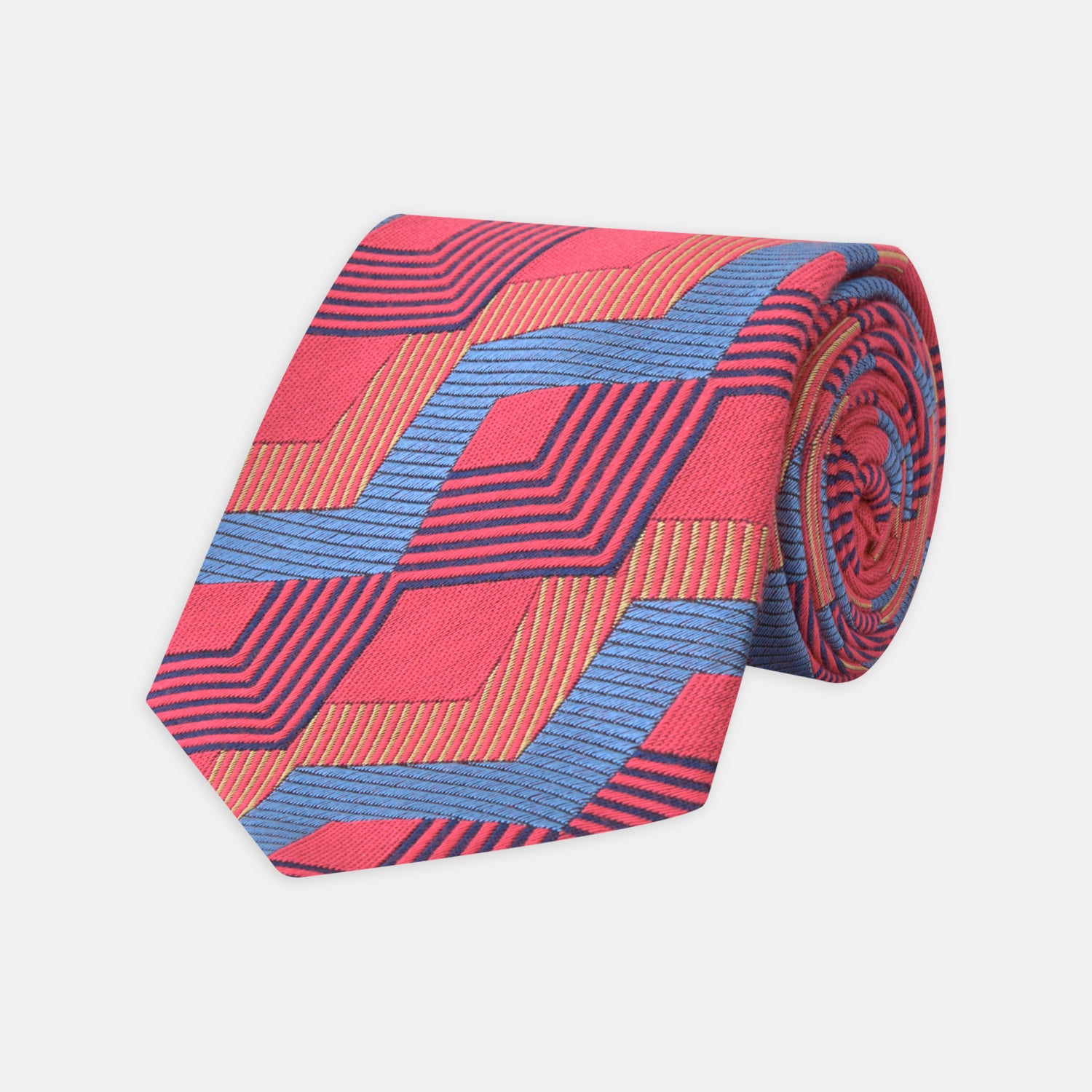 View 1 of product The Turnbull & Asser Red and Blue Zig Zag Silk Tie is a limited-run silk tie featuring interlocking geometric zigzag shapes and diagonal stripes in red, blue, gold, and navy.