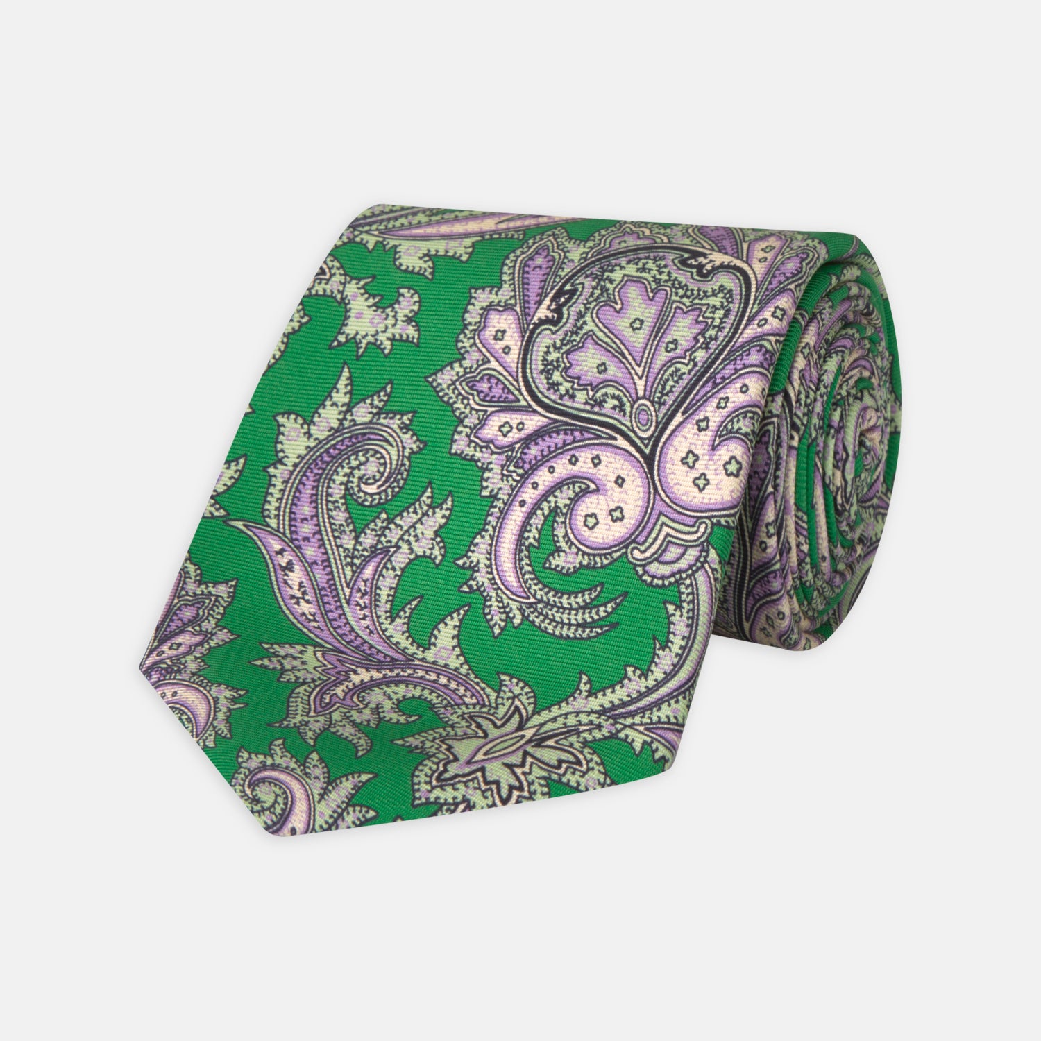 View 1 of product The Turnbull & Asser Green and Purple Large Paisley Printed Silk Tie features a light purple and white intricate paisley pattern, rolled up and set against a plain white background for timeless style.