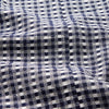 View 6 of product A barefoot person wears Turnbull & Asser's Navy Silk Chequered Kimono Gown with a belt over maroon pyjama sets, standing against a plain light background.