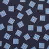 View 2 of product The Navy and Sky Blue Tiled Floral Silk Pocket Square by Turnbull & Asser features a geometric floral pattern in blue and white, a detailed border, and the brand's logo in the bottom right corner.