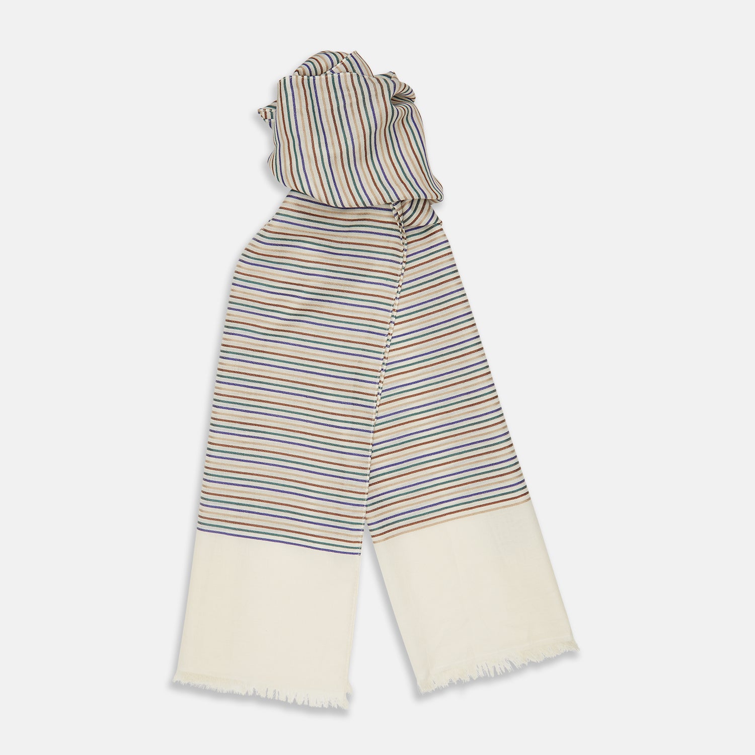 View 2 of product A man wearing a Turnbull & Asser Cream Abstract Stripe Print Lightweight Wool Scarf and a beige shirt stands outside by a tree, surrounded by greenery, gazing thoughtfully to the side.