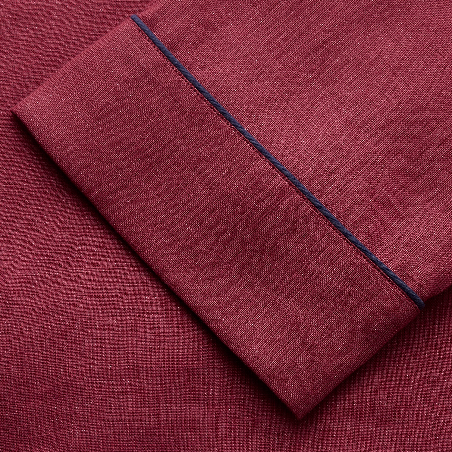 View 6 of product The Turnbull & Asser Burgundy Linen Modern Pyjama Set features a button-up, collared long-sleeve top with black piping and three pockets, plus matching pants with an elastic waistband.