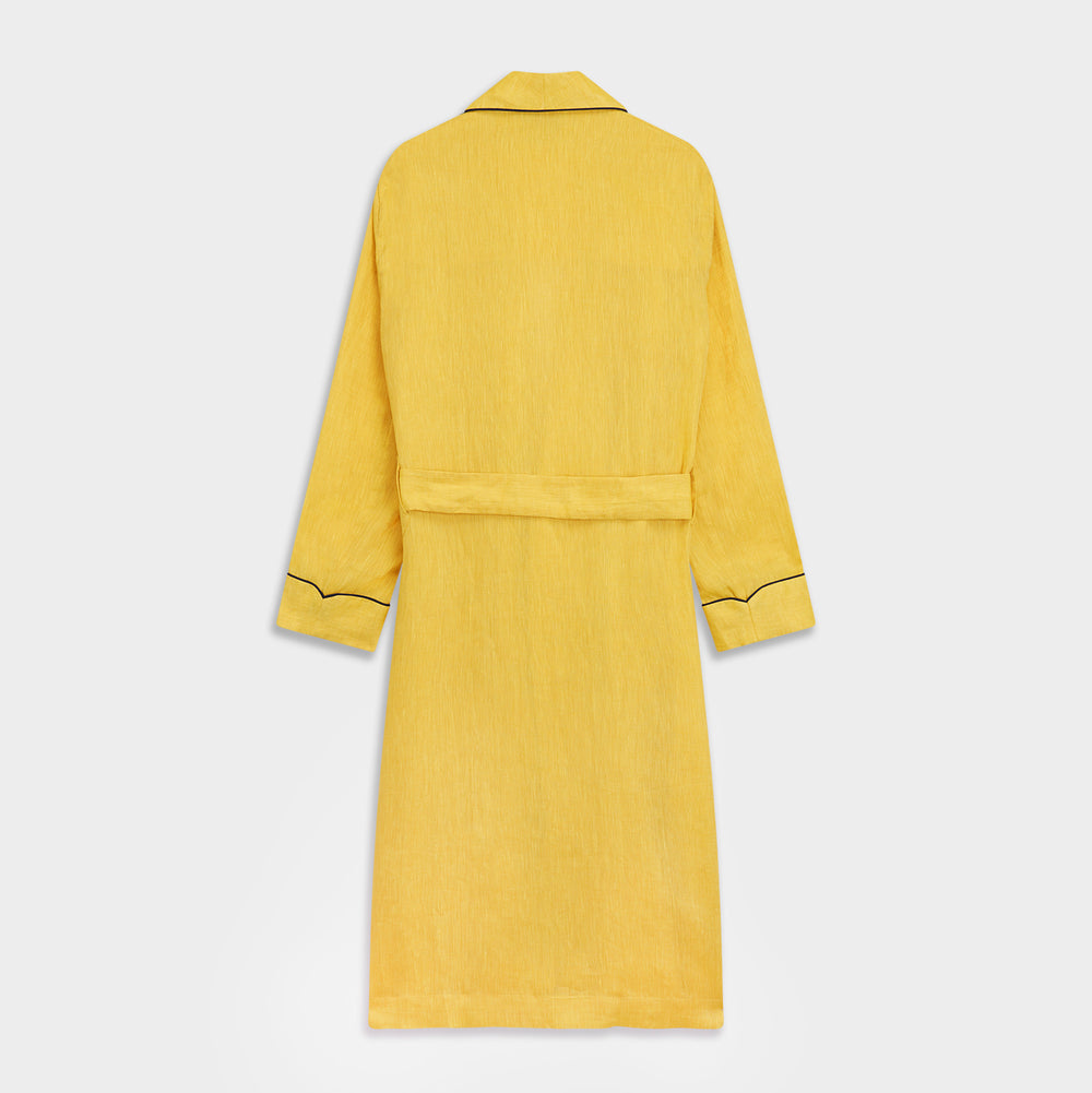 The Turnbull & Asser Ochre Linen Piped Gown features black piping on the collar, cuffs, and edges, a chest pocket, two front pockets, and a matching waist belt. Made with breathable linen for comfort, shown against a plain white background.