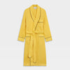 View 1 of product The Turnbull & Asser Ochre Linen Piped Gown features black piping on the collar, cuffs, and edges, a chest pocket, two front pockets, and a matching waist belt. Made with breathable linen for comfort, shown against a plain white background.