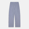 View 5 of product The Turnbull & Asser Navy & White Stripe Cotton Modern Pyjama Set features blue and white Bengal stripes with red piping, a long-sleeve button-up top, chest pocket, and matching pants. Shown laid flat on a white background.